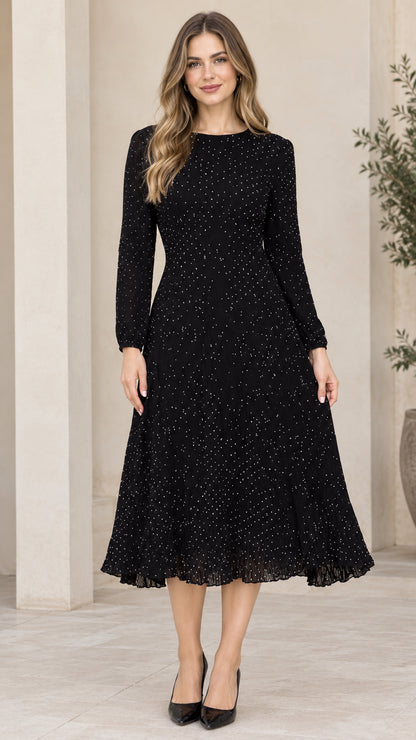 Front view of woman wearing black long sleeve micro dot A-line midi dress with pleated hem