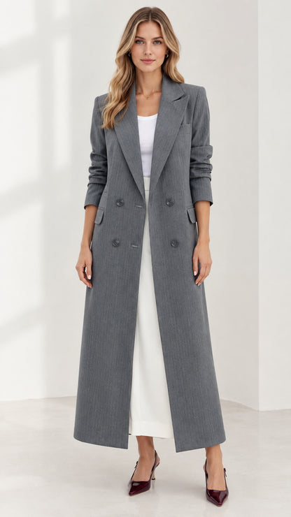Front full-length view of woman wearing grey tailored maxi coat over white outfit