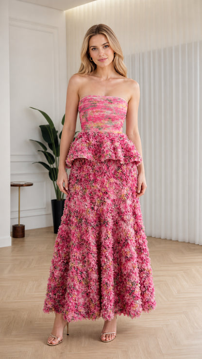 Front view of model wearing pink strapless floral ruffle peplum maxi dress