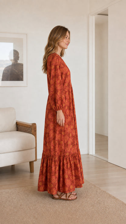 Side profile of model wearing rust floral print long sleeve maxi dress
