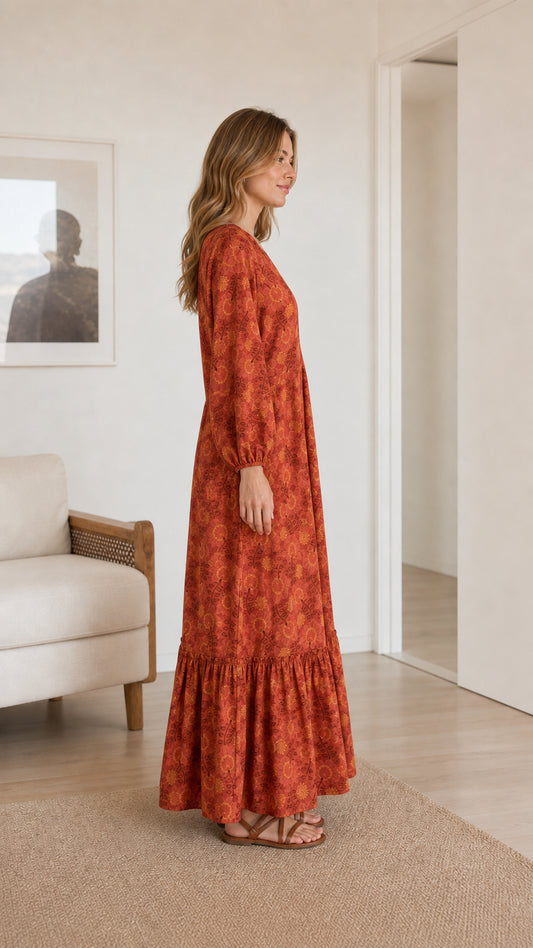 Side profile of model wearing rust floral print long sleeve maxi dress