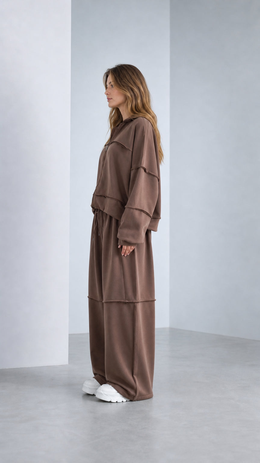 Side profile view of model wearing Chocolate Brown 2-piece lounge set with sneakers