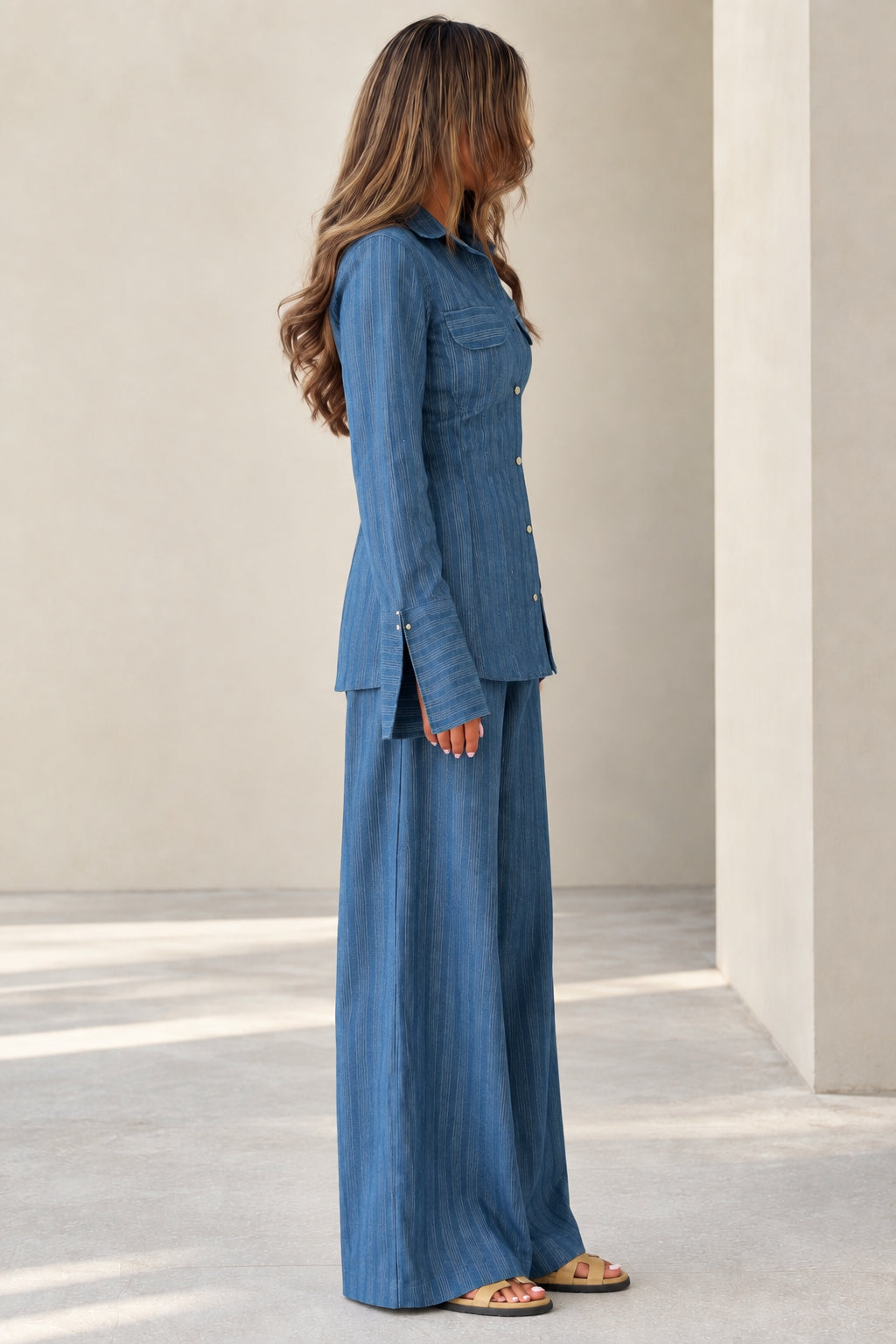 Side profile view of women's blue textured matching pant set