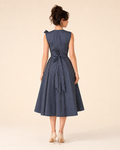 Back view of navy sleeveless striped midi dress with tie waist and flared midi skirt