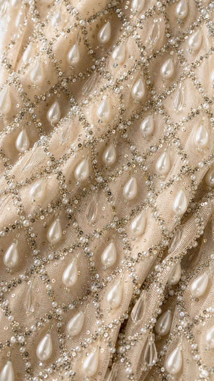 Close-up detail of geometric mesh fabric with pearls and sequins