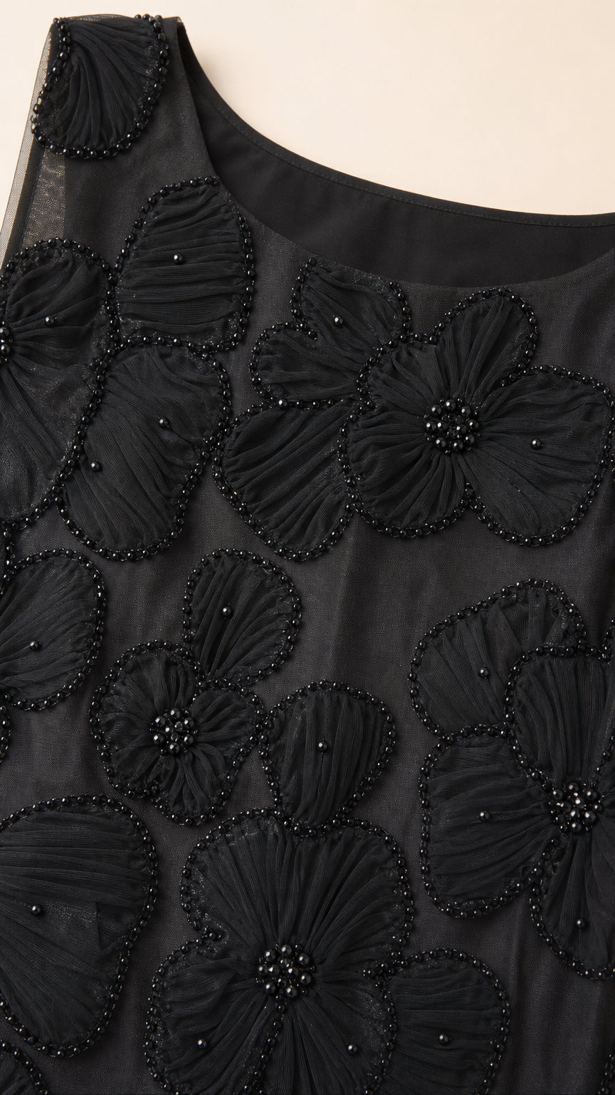 Close-up detail of black textured 3D floral petal applique and tonal beadwork