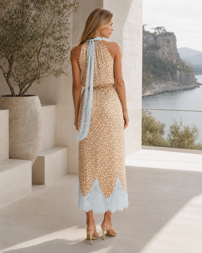 Back view of beige printed halter midi dress with long neck tie and contrast hem