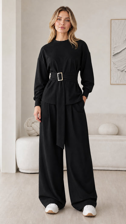 Model wearing black belted long sleeve top and wide leg pants matching set