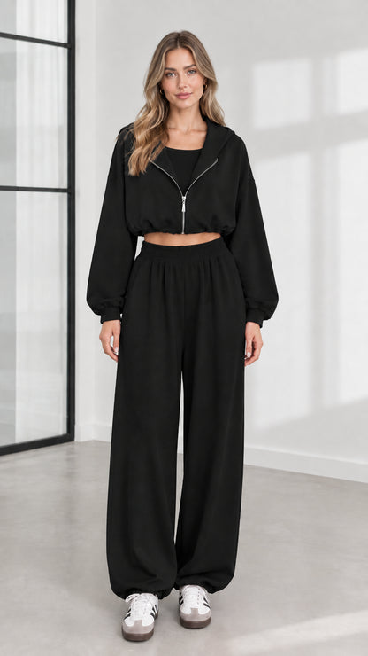 Front view of model wearing black 3-piece cropped zip hoodie and wide-leg sweatpants set