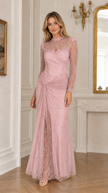 Full front view of a woman wearing a dusty pink long sleeve lace evening gown with front drape slit