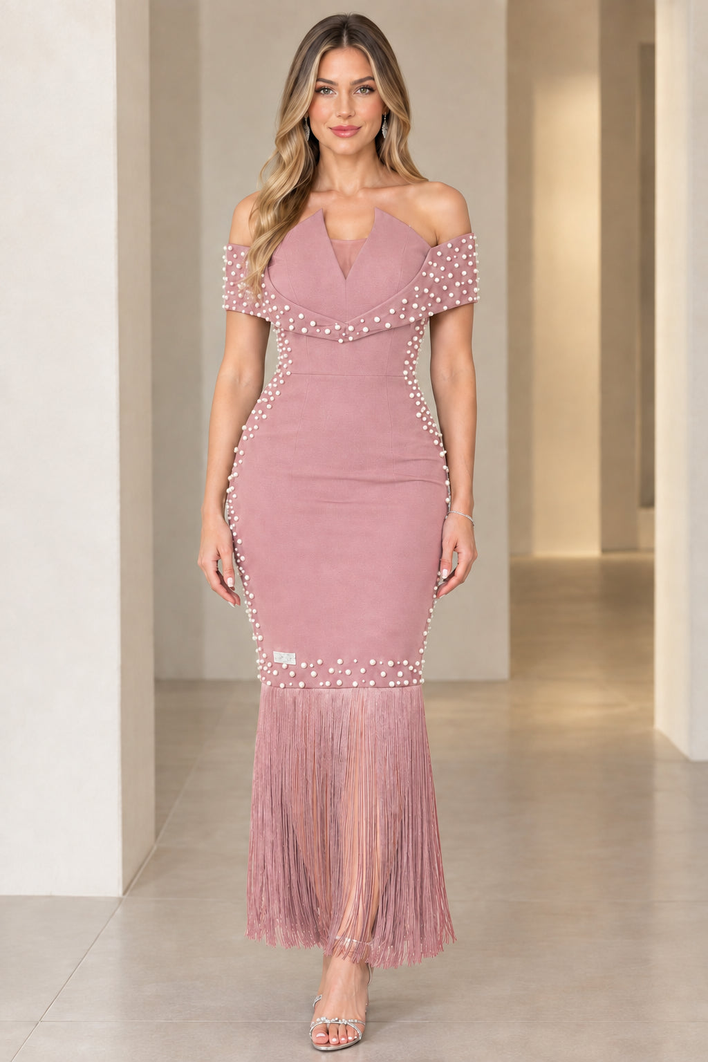Model wearing dusty rose off-the-shoulder pearl embellished evening dress with tassel hem